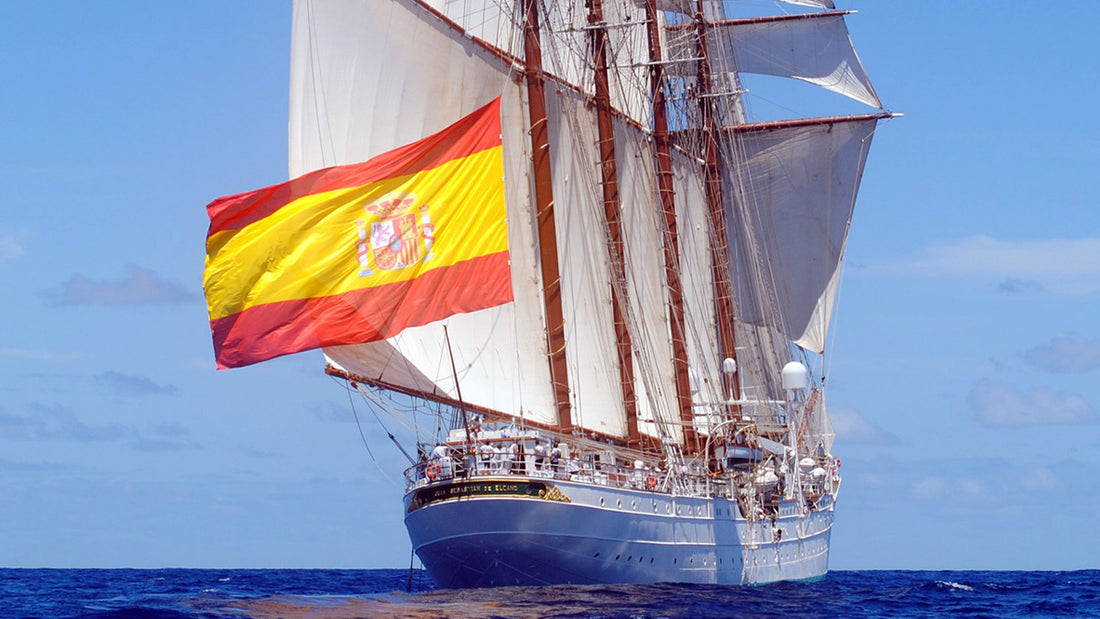 El Juan Sebastián Elcano navegando a vela con el pabellón español flameando orgulloso en la poopa