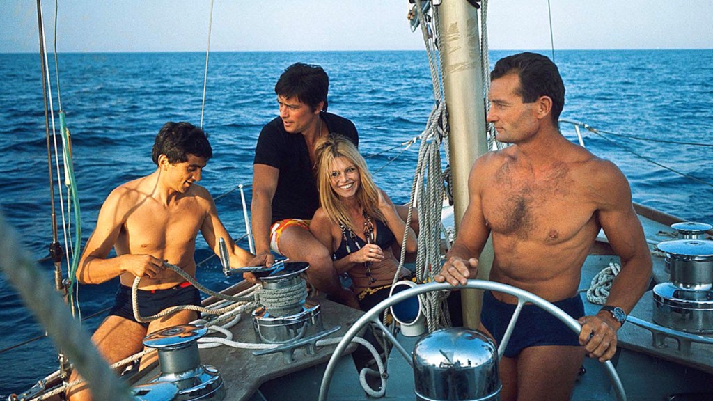 Alain Delon, Brigitte Bardot y Eric Tabarly. Bardot, musa francesa de los años 70 y Alain Delon navegando a bordo del uno de los míticos Pen Duick en la costa de Saint Tropez, frente a Saint-Raphaël a finales de agosto de 1968.. Fotógrafo: Jean-Pierre Biot para «Paris Match