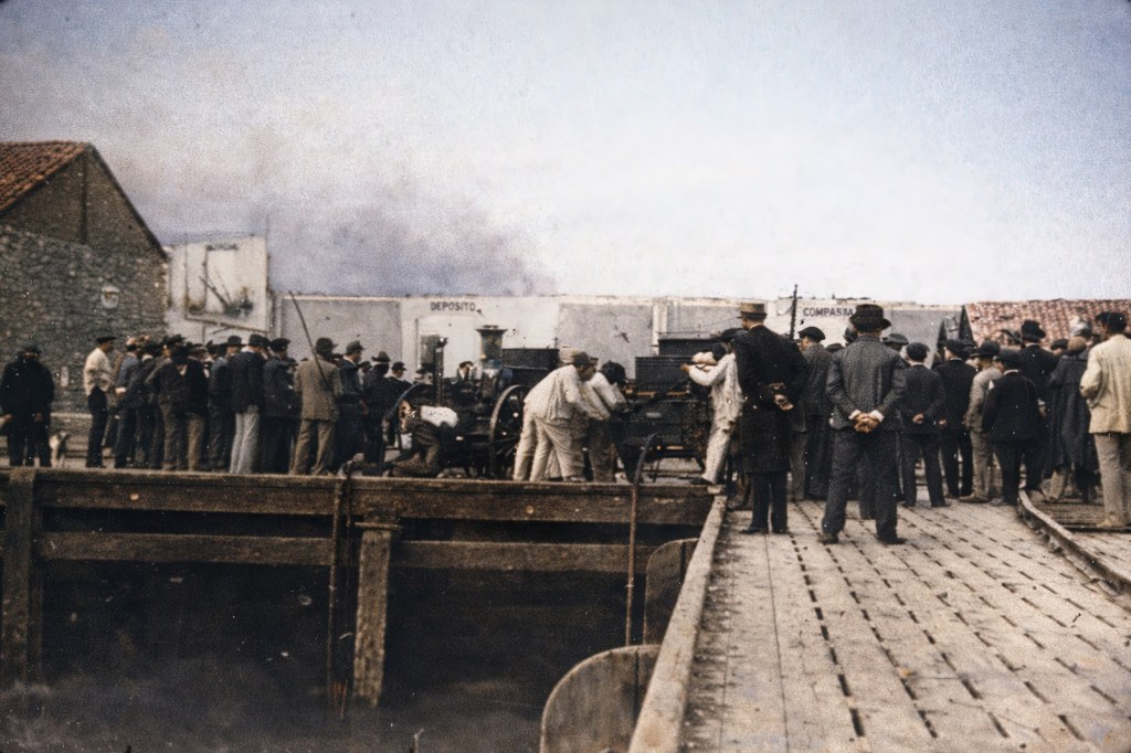 Curiosos contemplando las labores de extinción del fuego a bordo del barco
