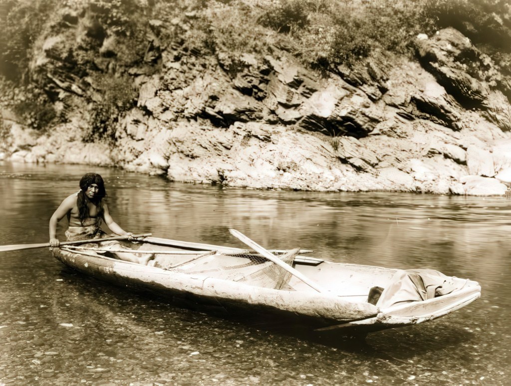 Fotograbado de un hombre yurok remando una canoa tradicional yurok